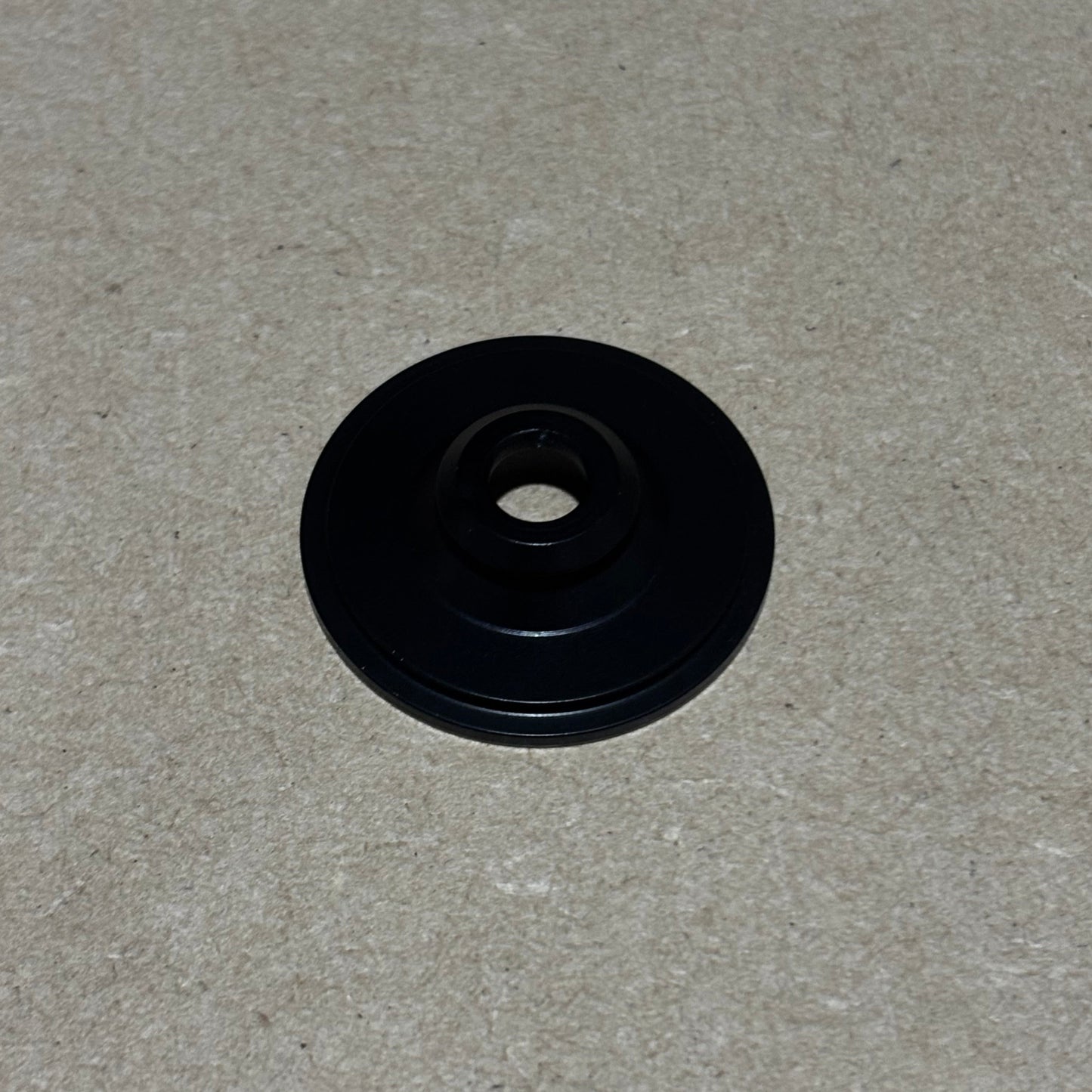 Black circular object on a gray textured background