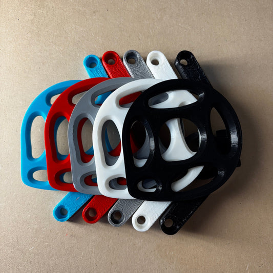 Stack of black, white, red, and blue metal brackets on a brown surface